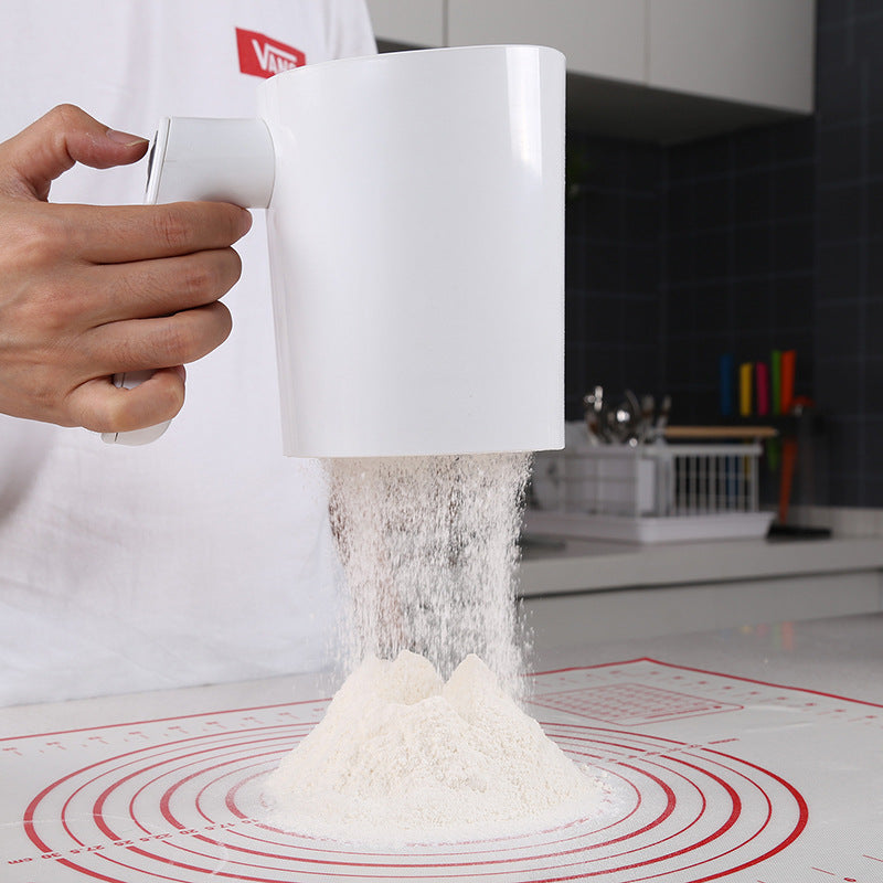 Electric flour sifter sifting flour onto a pastry mat
