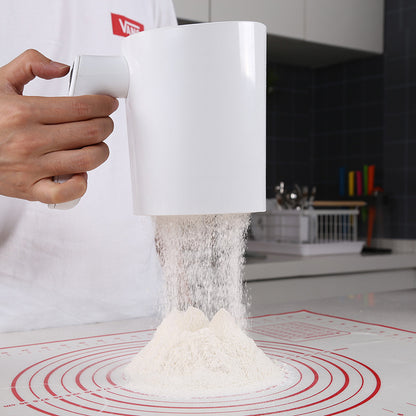 Electric flour sifter sifting flour onto a pastry mat
